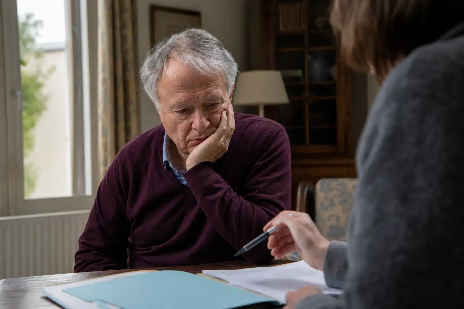 Homme âgé pensif consultant des documents avec une femme